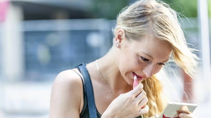 Mujer maquillándose con lápiz labial