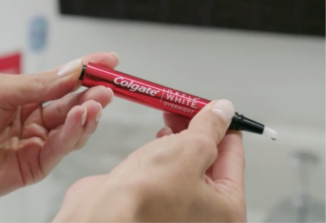 Aplica el suero blanqueador de dientes Optic White O2 de Colgate en los dientes Aplica el suero blanqueador de dientes Optic White O2 de Colgate en los dientes